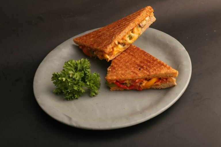 Golden grilled cheese sandwich cut in half with melted cheese